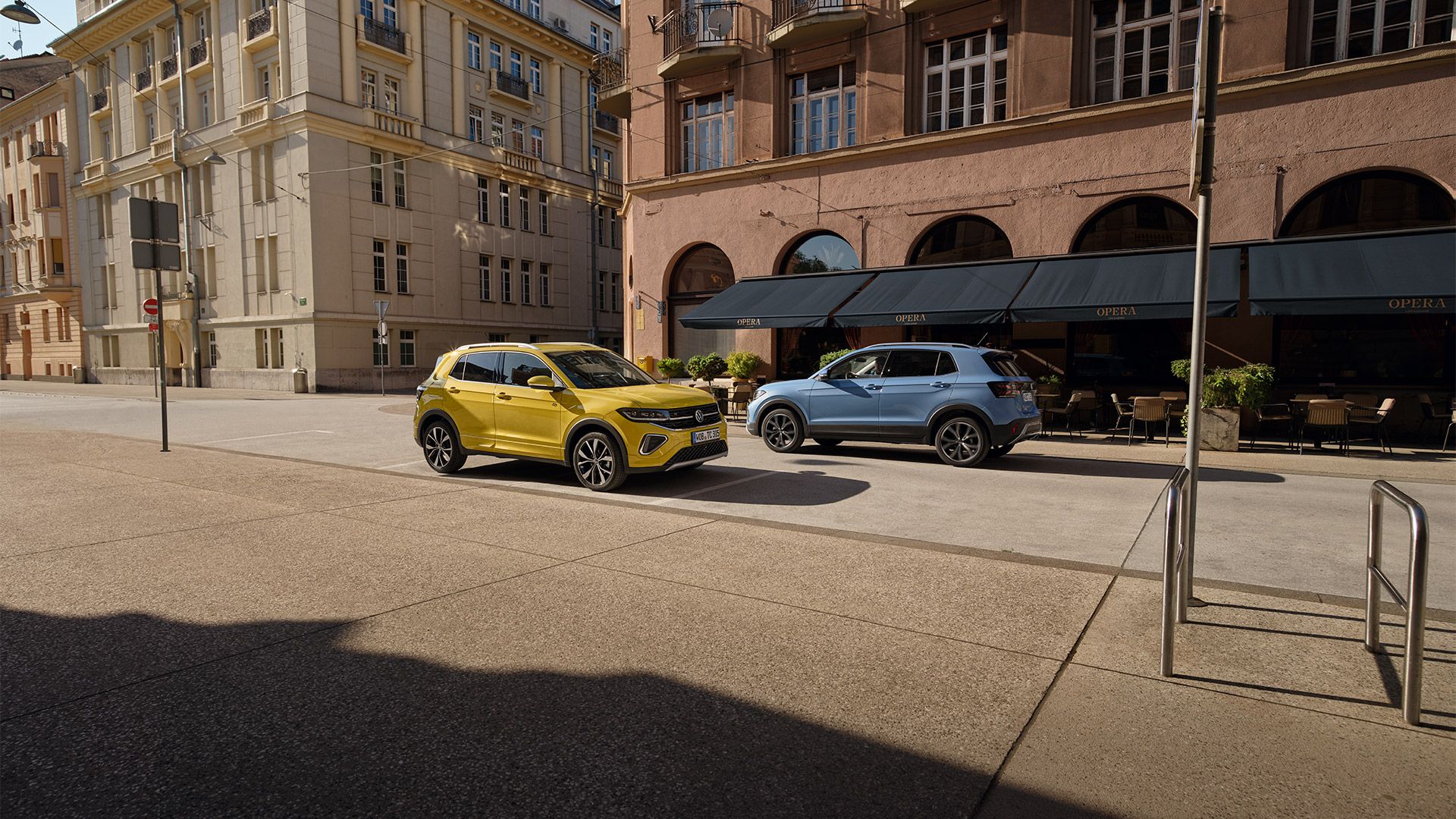 Um VW T-Cross amarelo e um azul passam um pelo outro numa estrada.