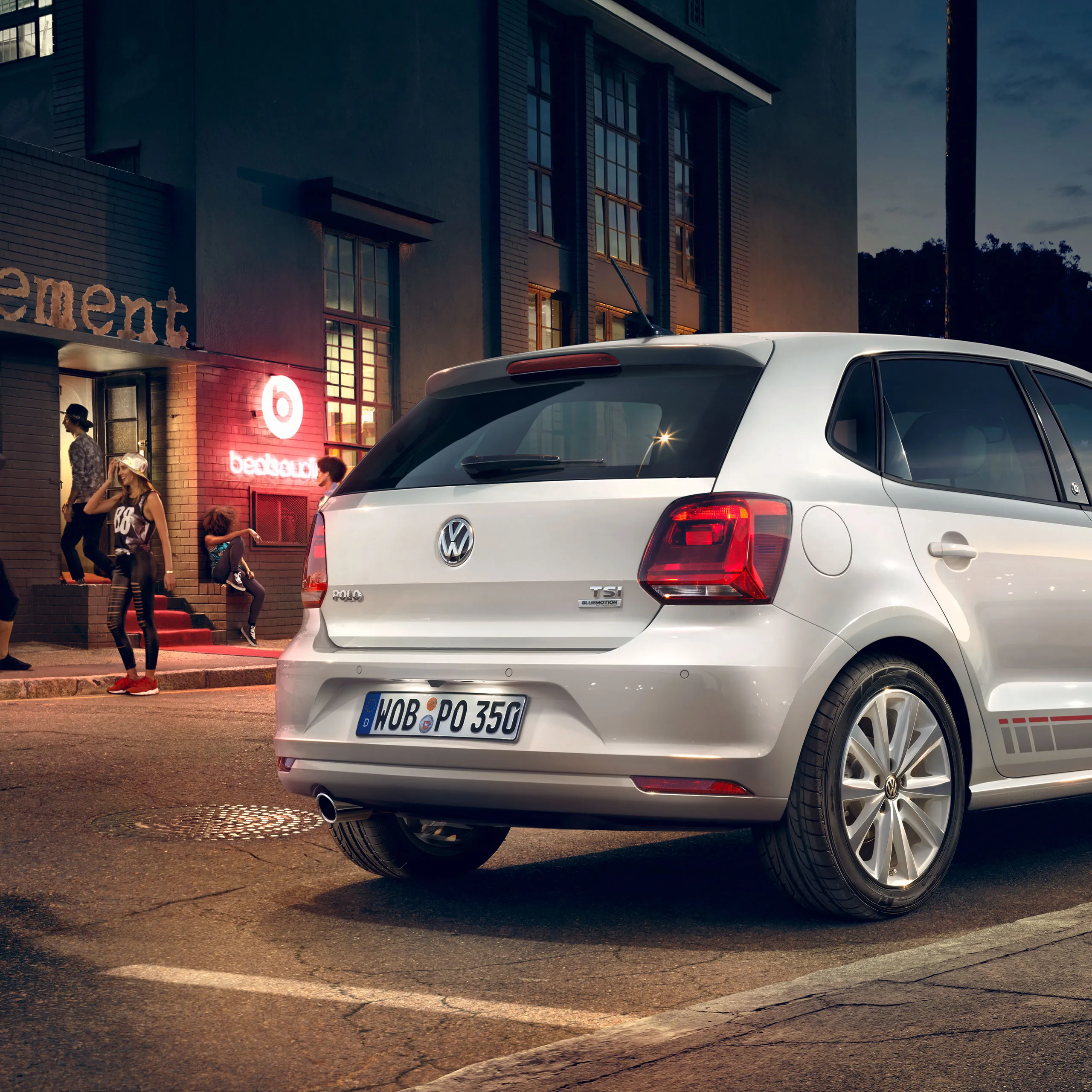 A vista traseira de um Volkswagen Polo 5 prateado "beats" à noite em frente de uma discoteca