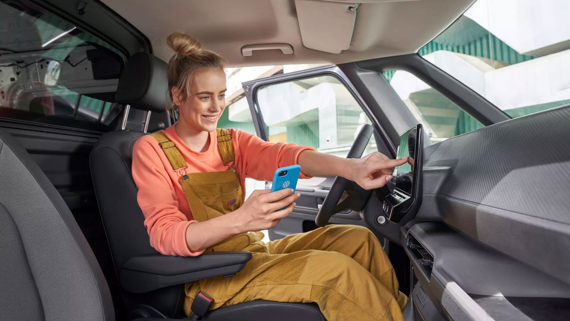 Eine Frau sitzt in einem VW ID. und testet das Infotainment System