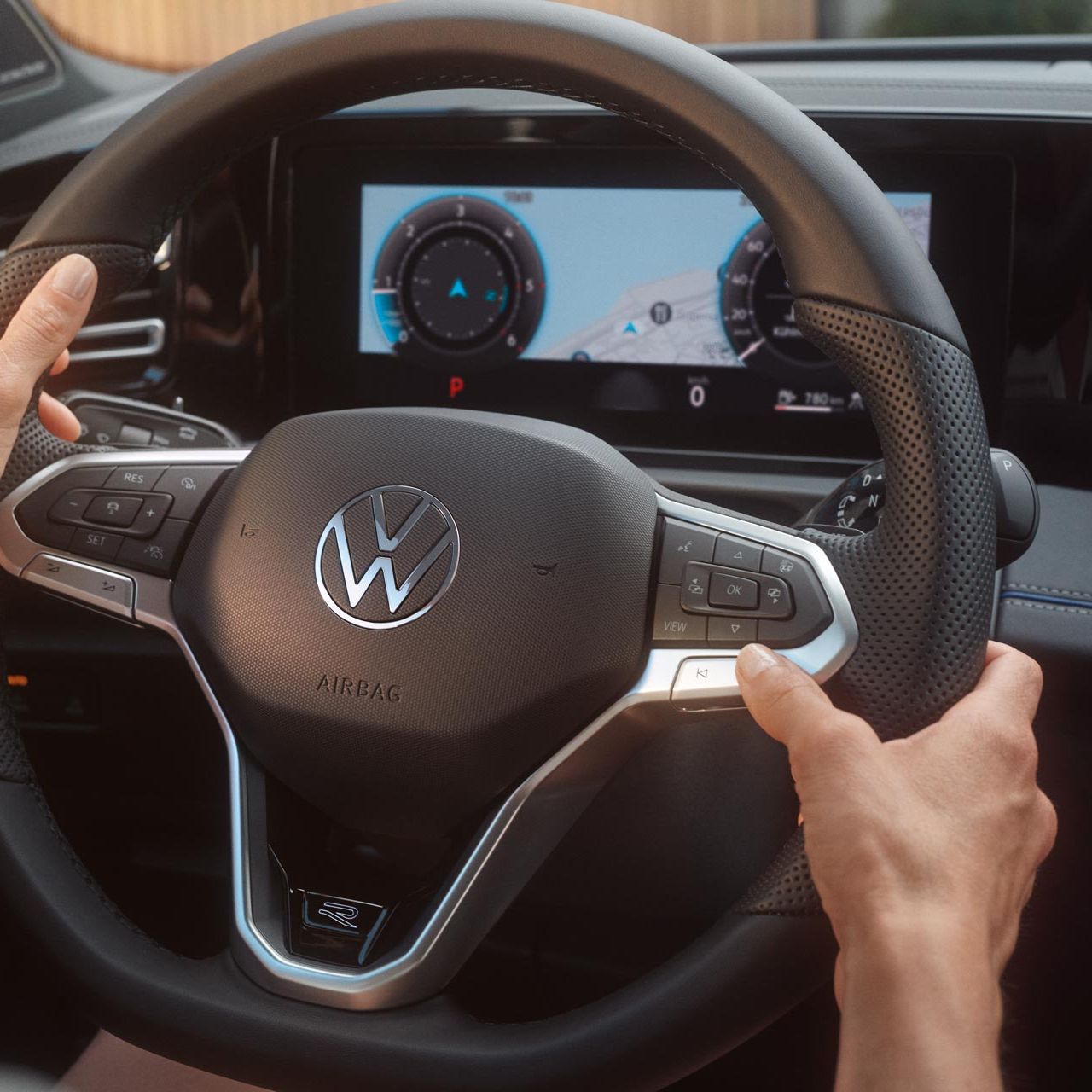 Vista detalhada do cockpit de um VW Tiguan. Duas mãos agarram o volante.