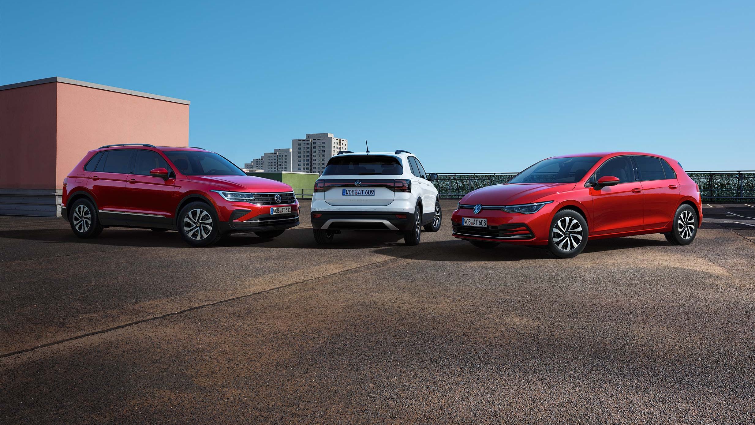 Um VW T-Cross, um VW Golf e um VW Tiguan lado a lado sob um céu azul