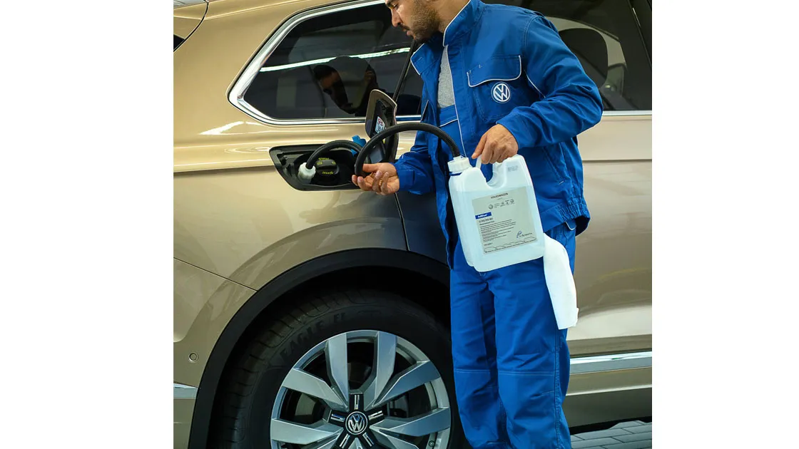 Ein VW Service-Mitarbeiter füllt AdBlue nach 