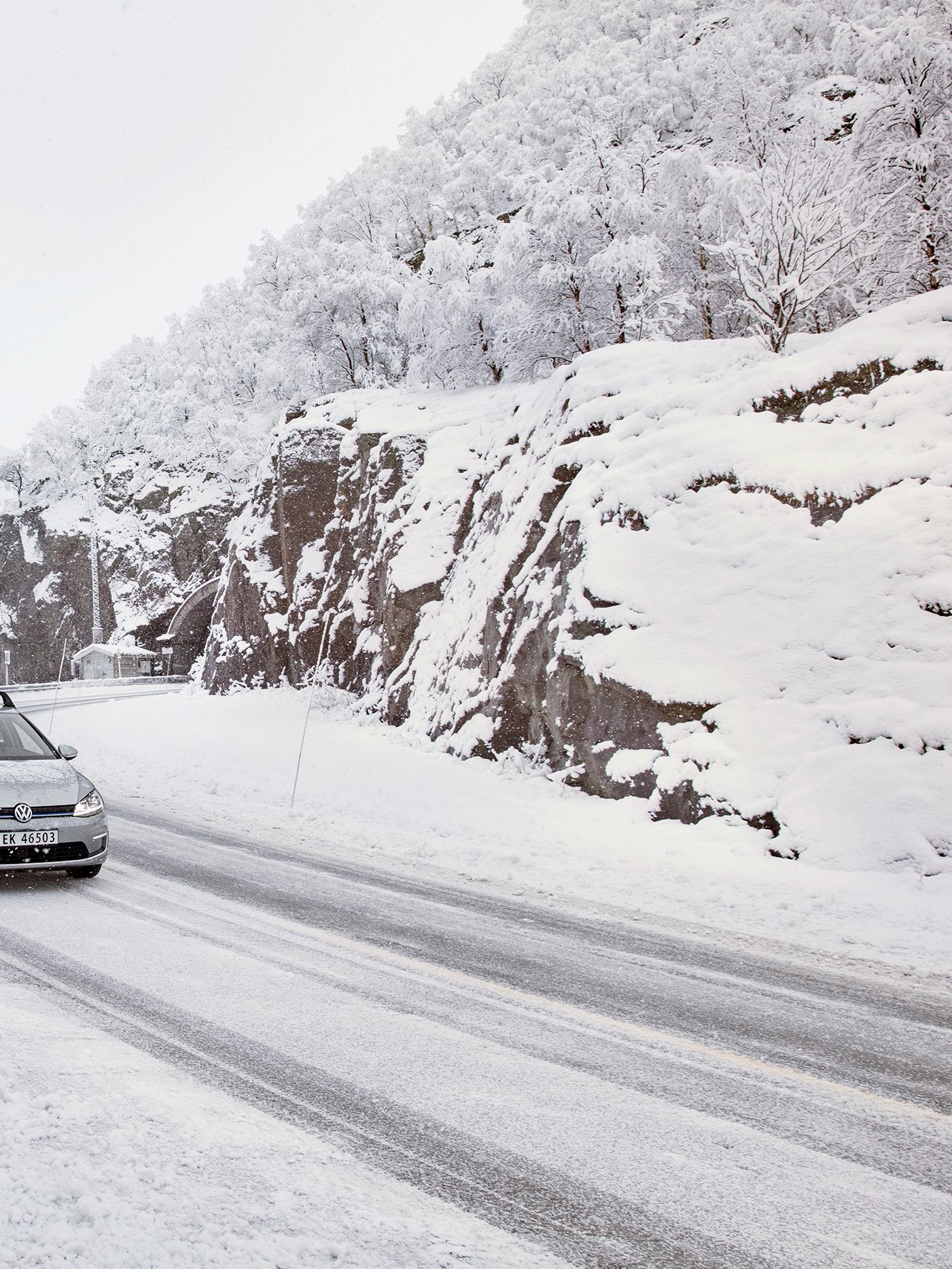 e-Golf com suporte para prancha de snowboard a conduzir através de uma paisagem de montanha com neve