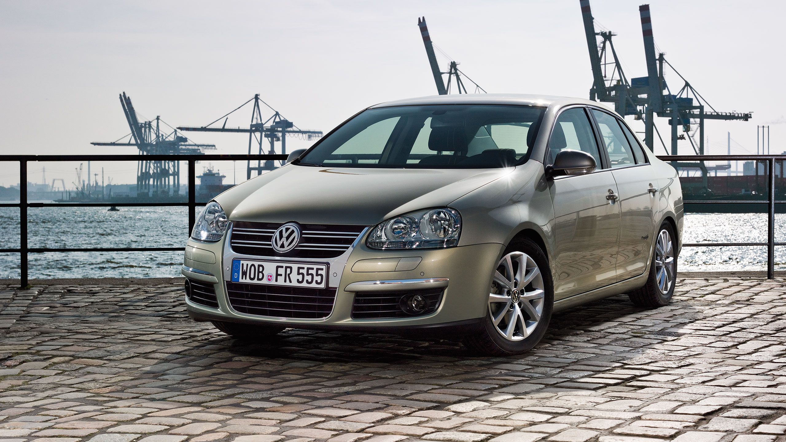 Um carro Jetta 6 cinzento num caminho de calçada, num porto.