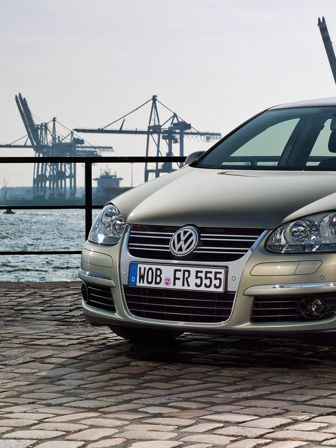 Um carro Jetta 6 cinzento num caminho de calçada, num porto.