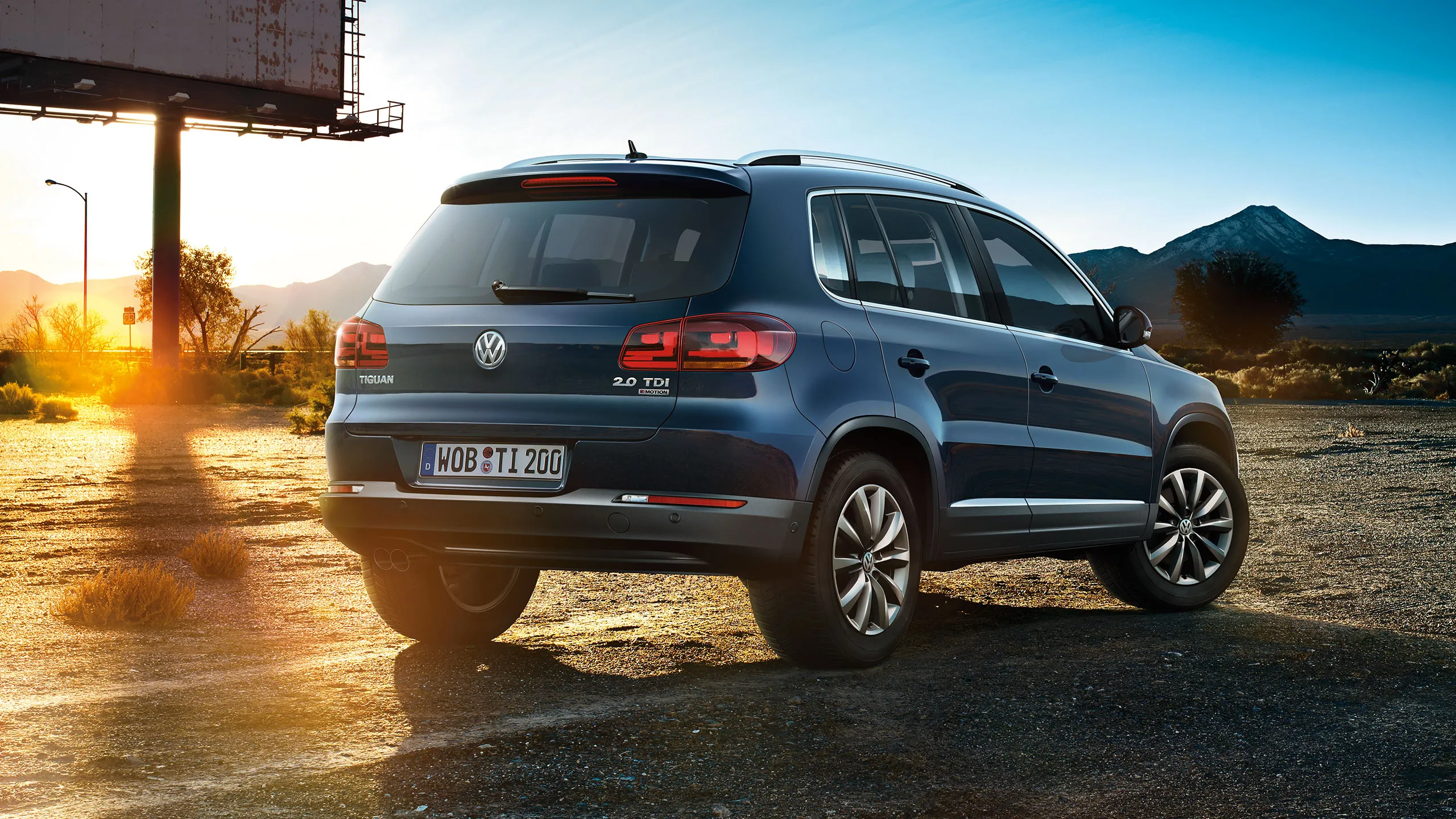 Um carro Tiguan 1 estacionado numa estrada de terra ao pôr-do-sol.