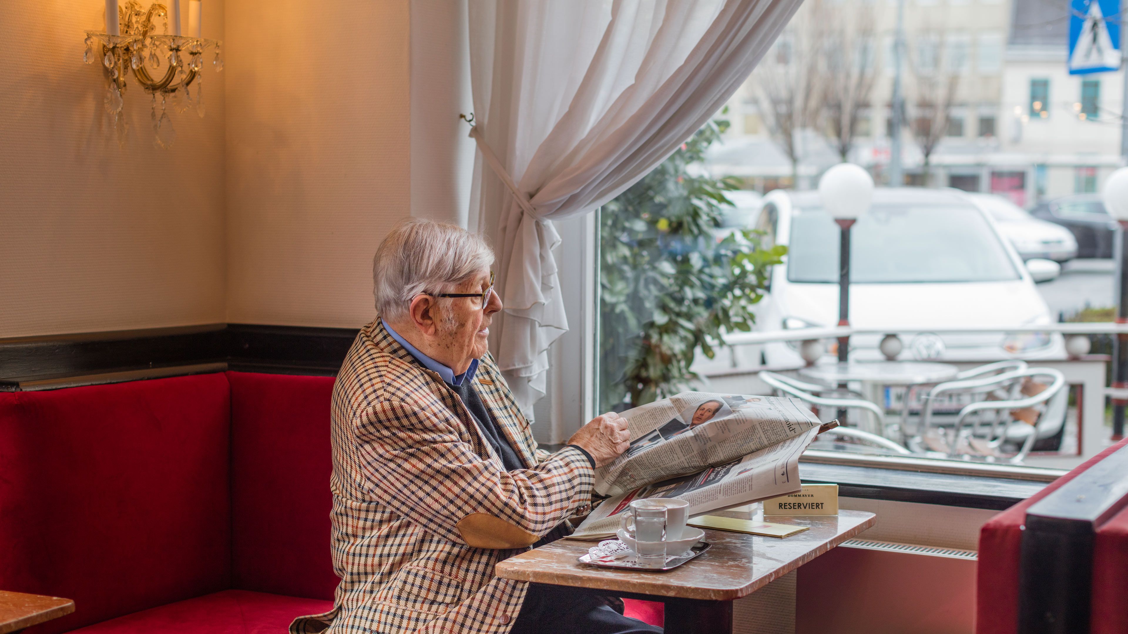 Heinz Gerhard senta-se à janela no Café Dommayer e olha para o seu e-up!