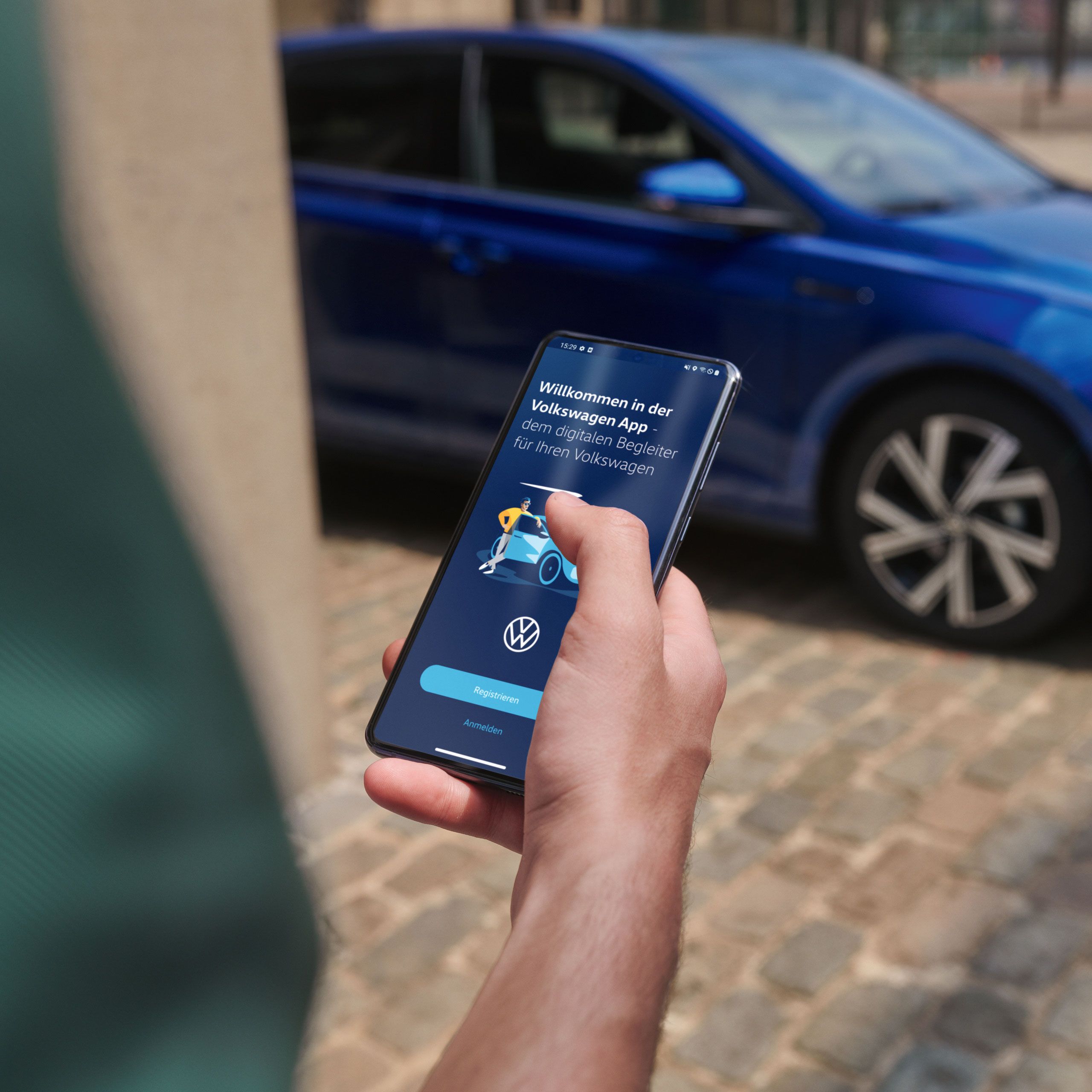 Eine Person hält ein Smartphone, auf welchem die Volkswagen App geöffnet ist 