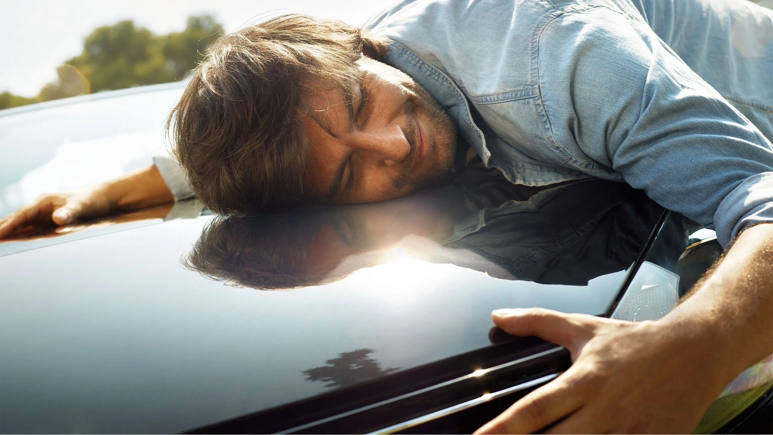 Um homem abraça o capot do seu VW preto