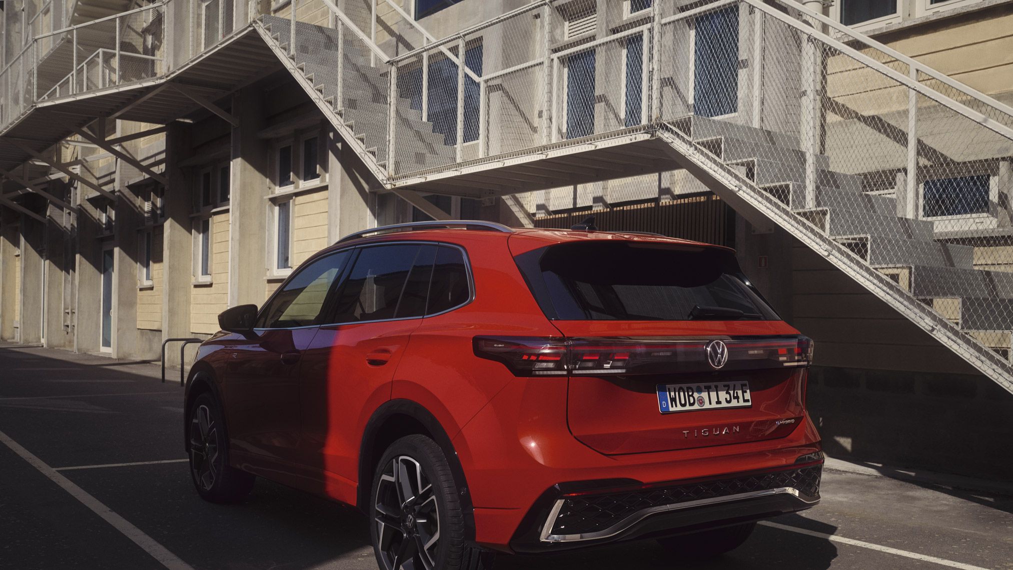 Vista traseira de um VW Tiguan estacionado em frente a um edifício.