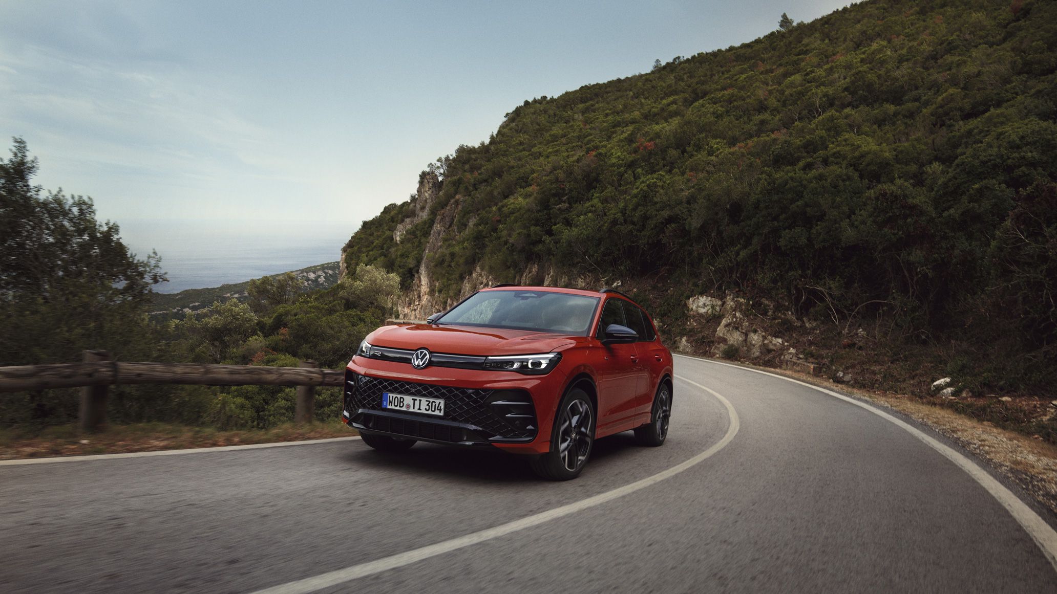 O VW Tiguan vermelho desloca-se ao longo de uma estrada sinuosa.