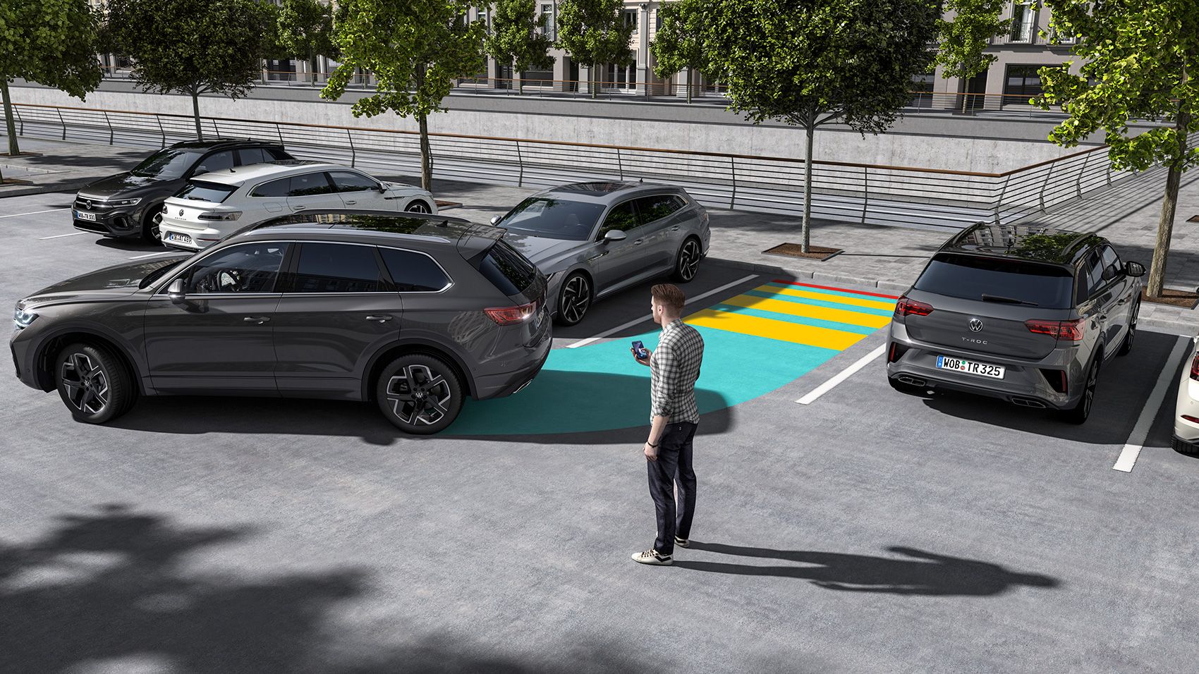 Ao estacionar, o VW Touareg utiliza o assistente de estacionamento "Park Assist Pro". Ao seu lado, um homem controla o processo através do seu smartphone.