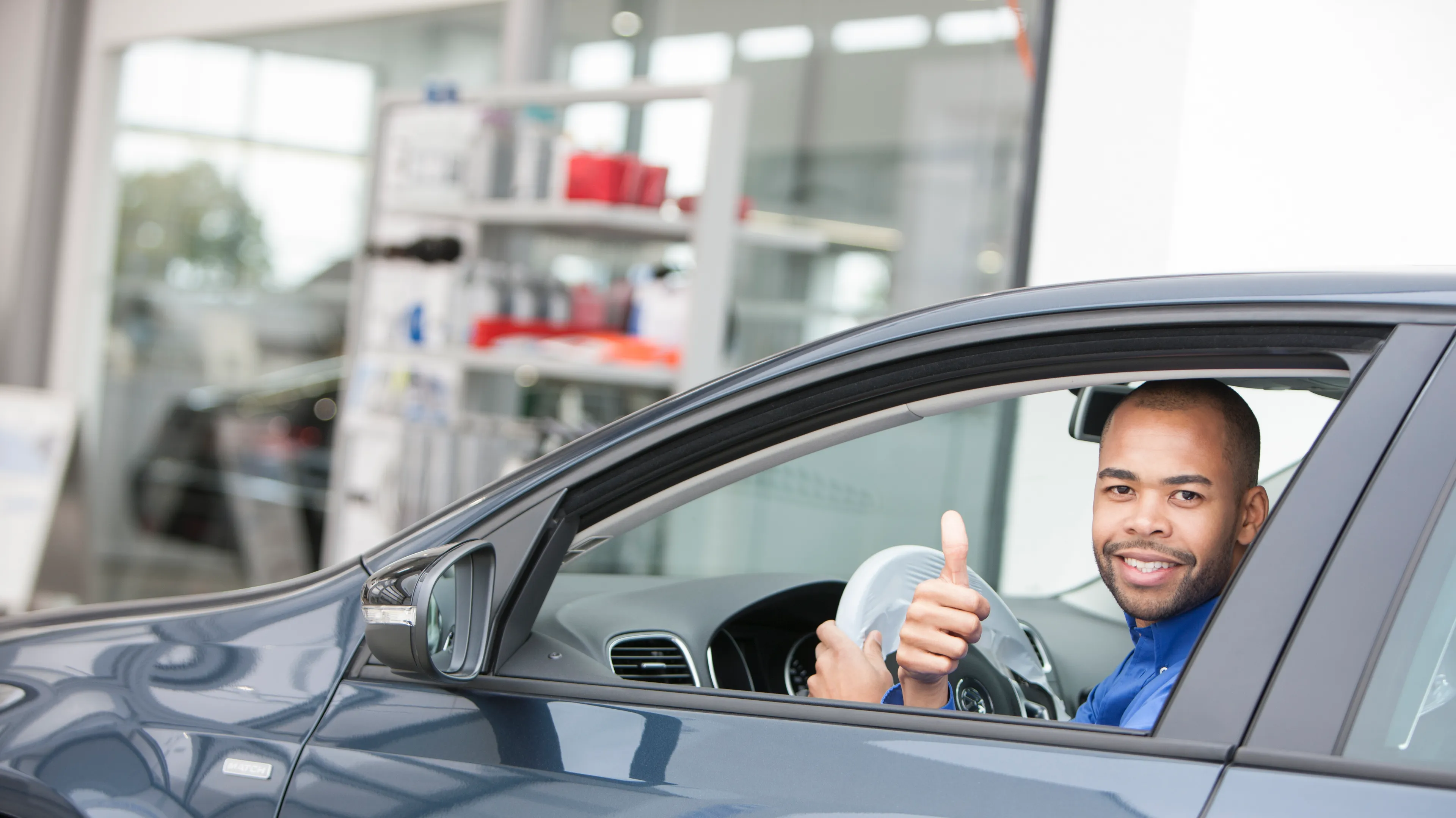 Mann in Volkswagen zeigt Daumen hoch