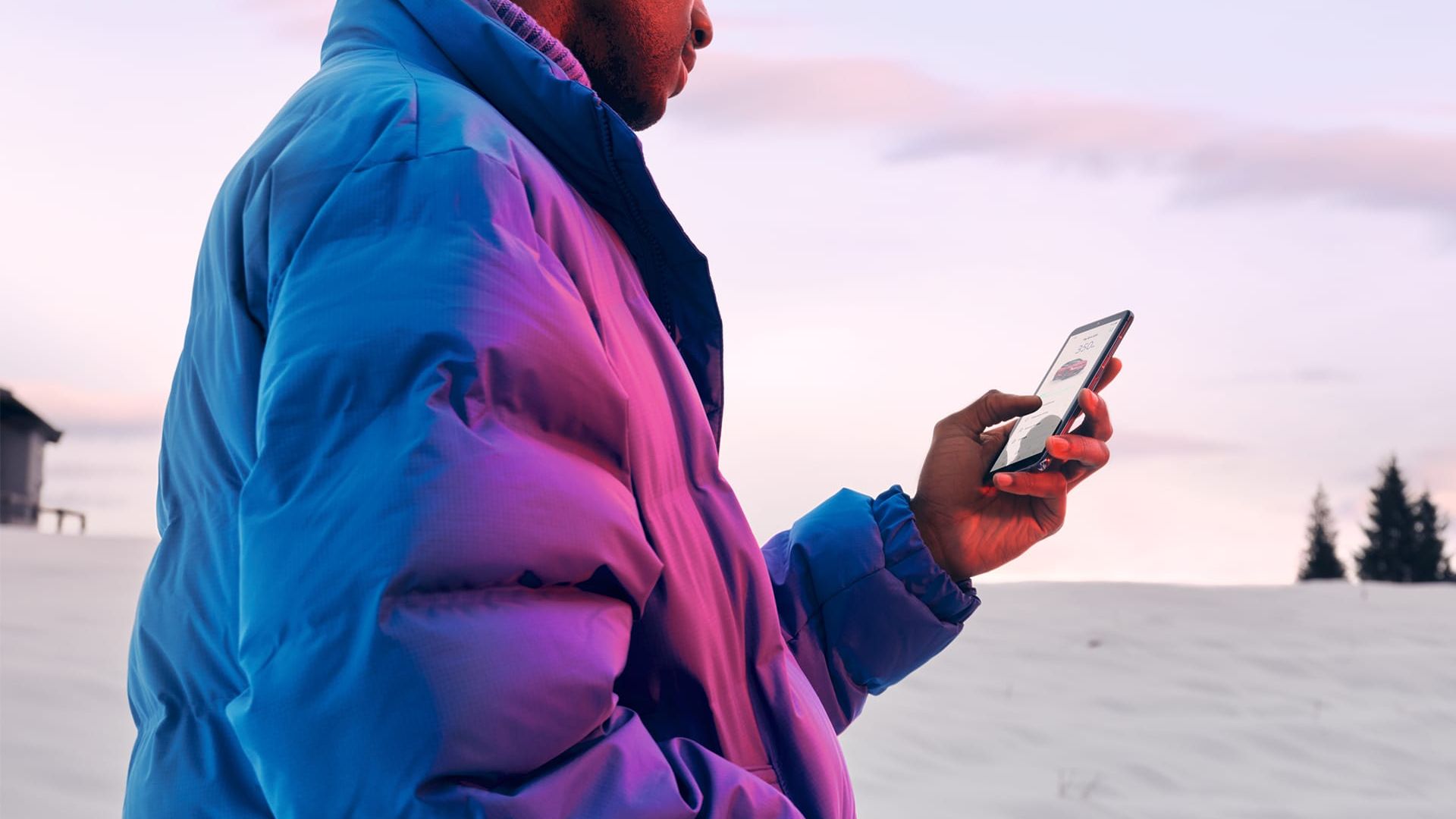 Homem em paisagem de inverno a olhar para um smartphone