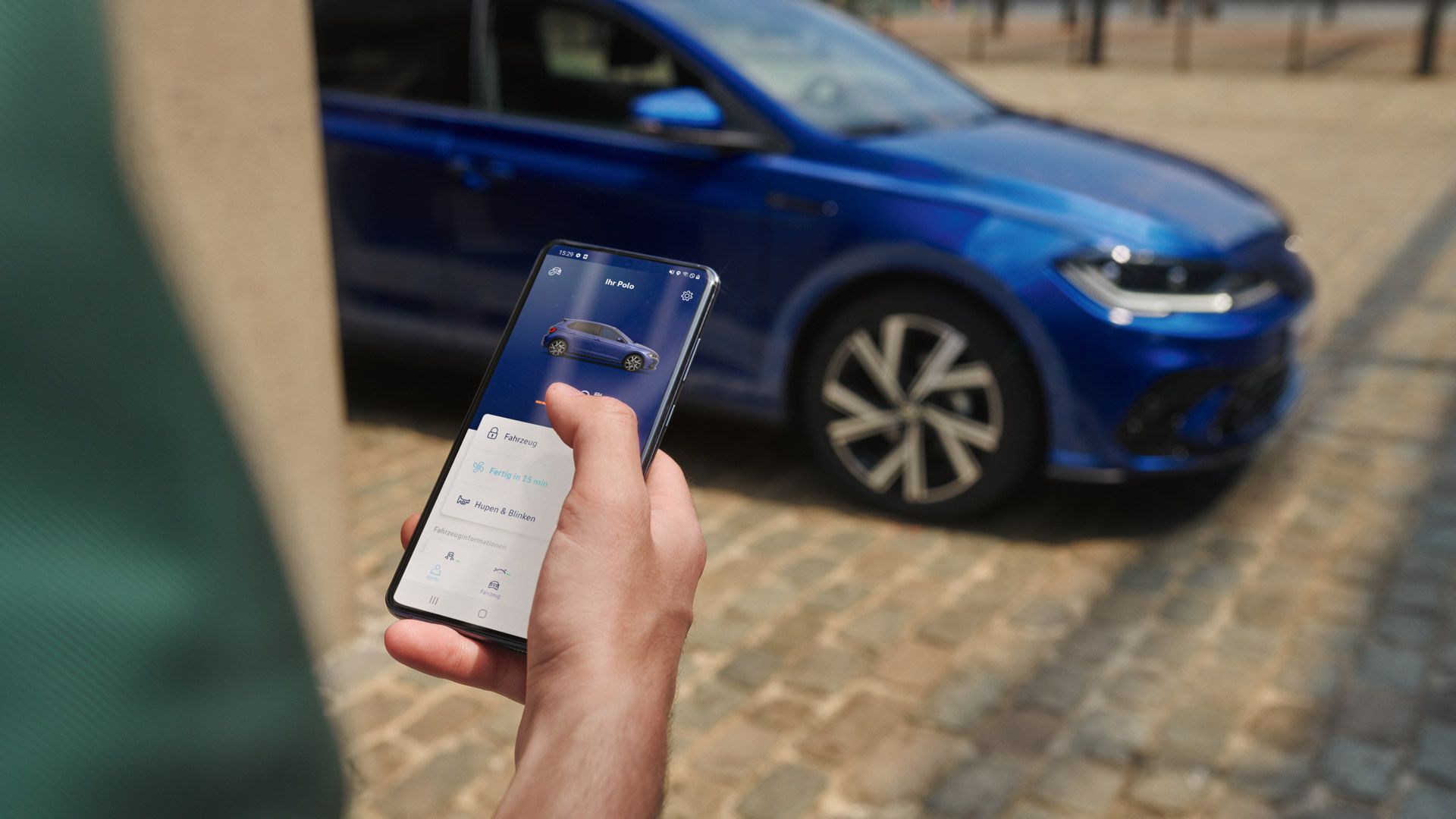 Vista do ecrã de um telemóvel com dados de veículo do Polo; em segundo plano, o VW Polo azul, estacionado.