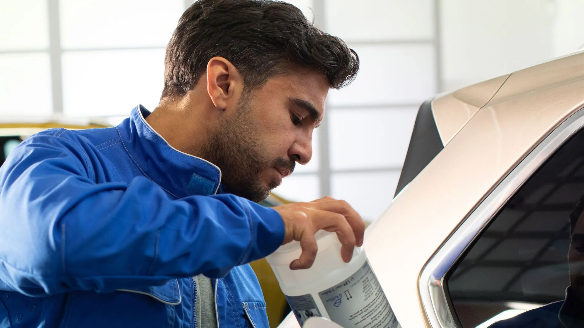 Um mecânico enche o tanque de um VW com AdBlue