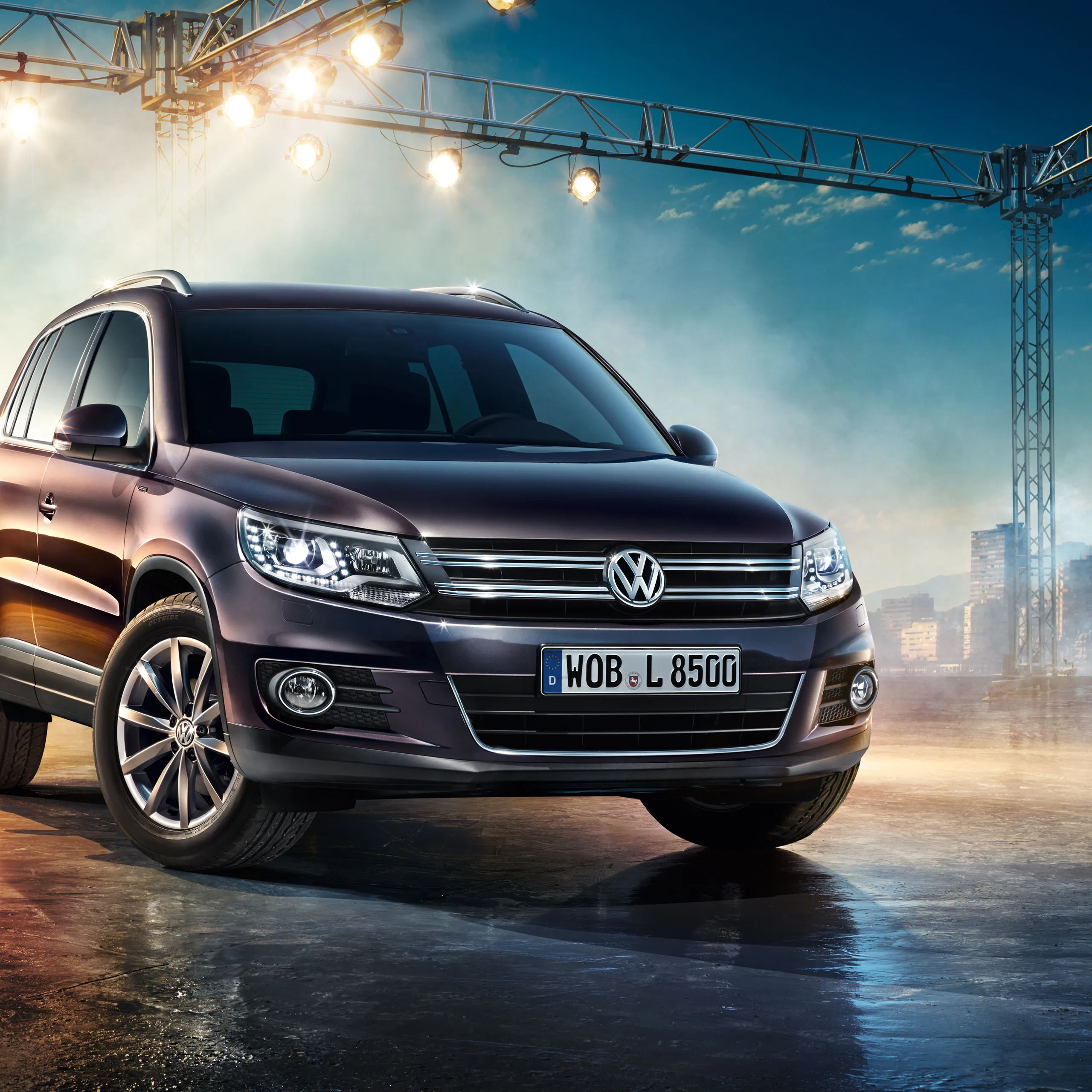 Um SUV VW Tiguan 1 estacionado debaixo de alguns holofotes.