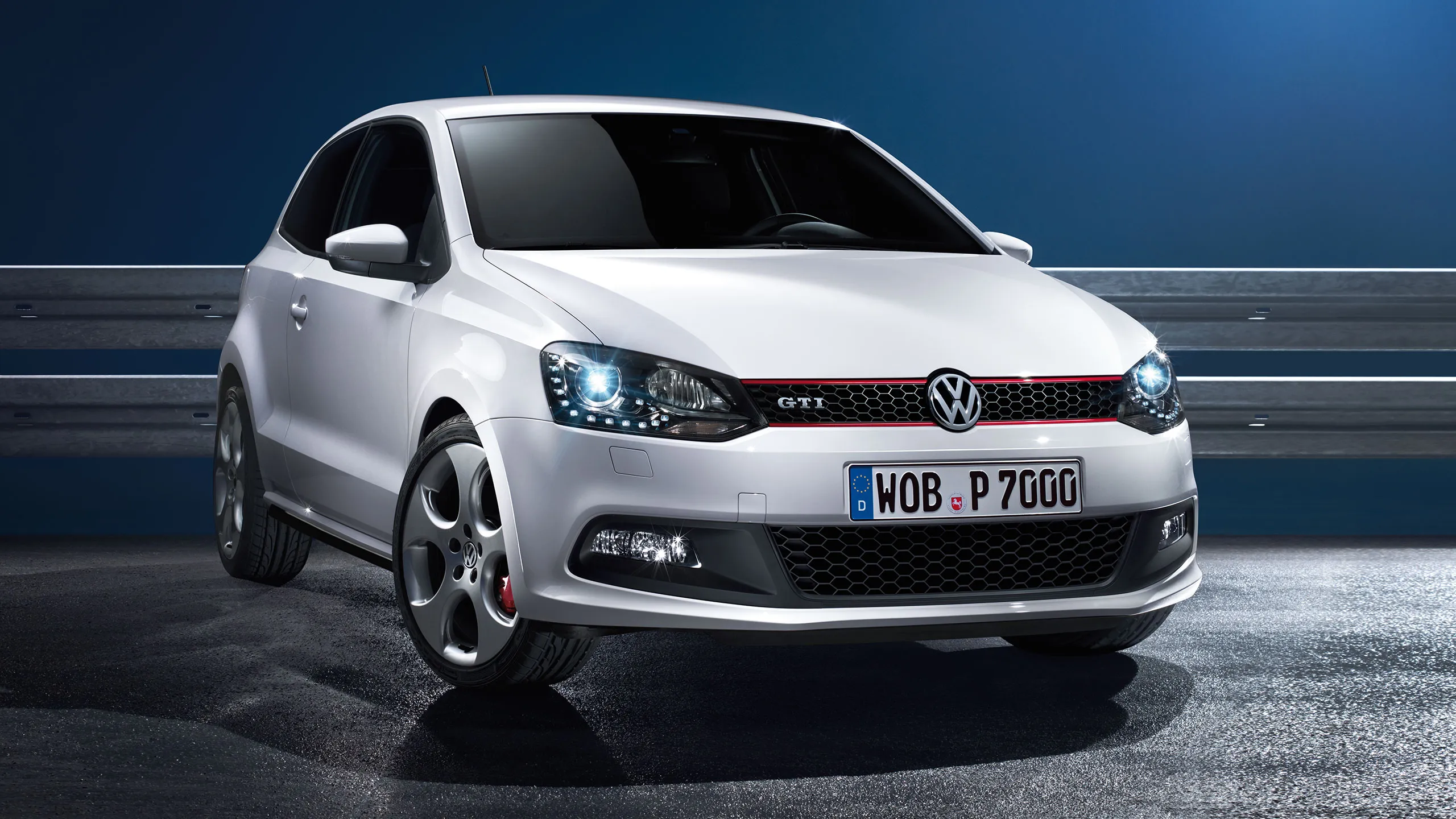 A vista frontal de um VW Polo 5 GTI branco numa estrada à noite