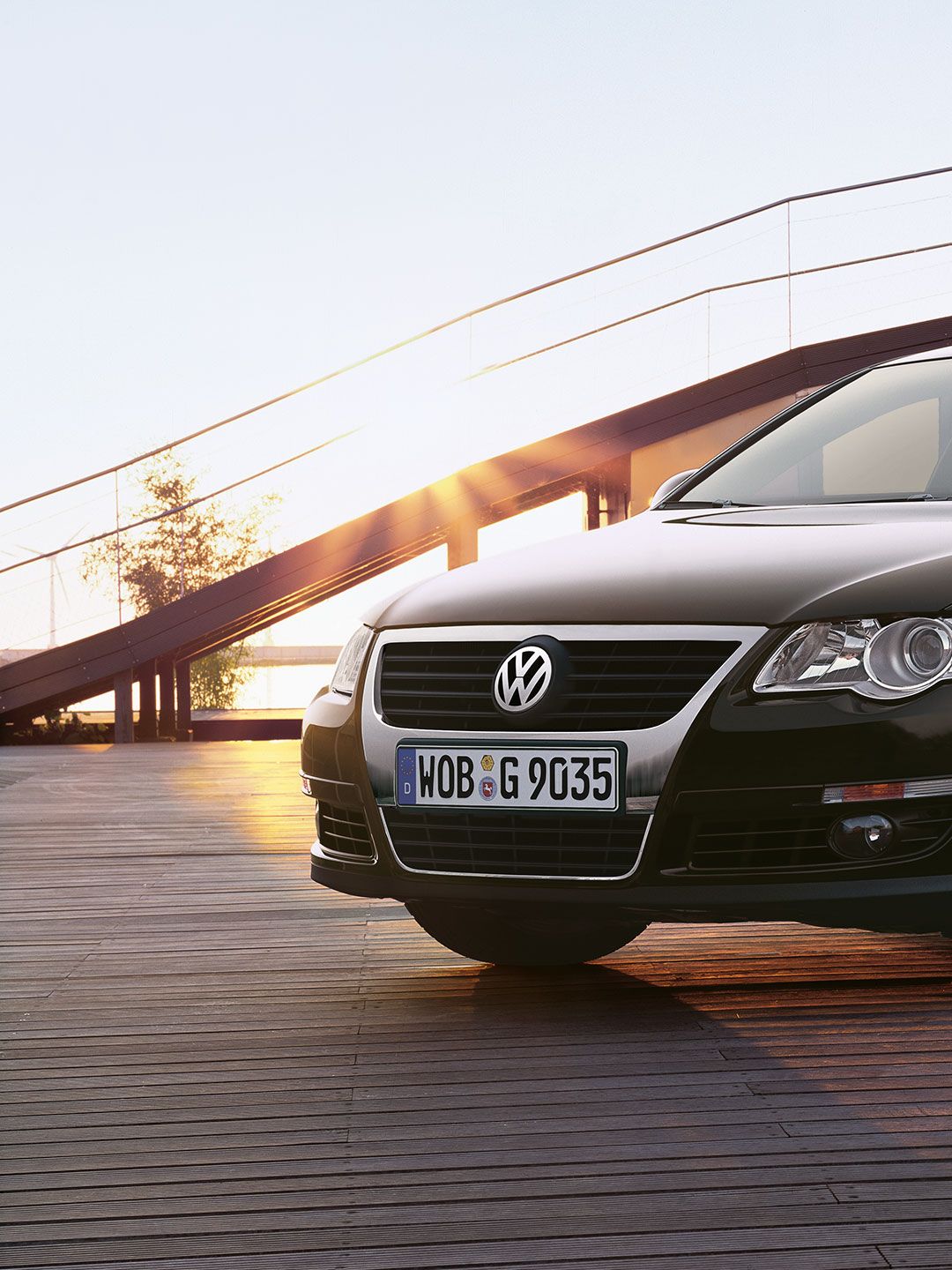 Um VW Passat B6 preto estacionado num terraço de madeira.